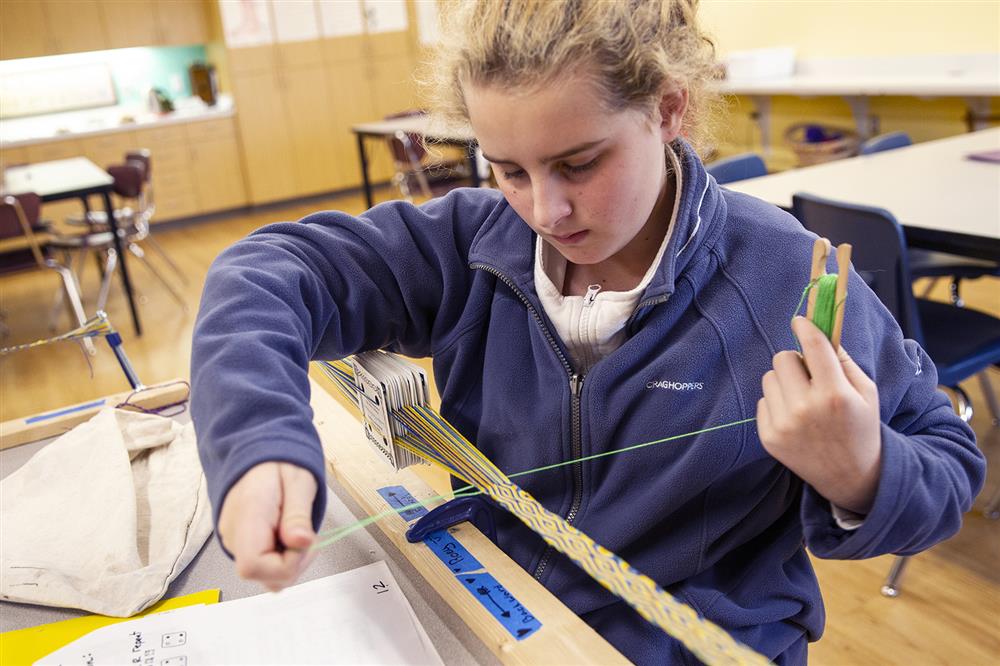 A student works on a Tablet Weaving project at Winterberry Charter School. 